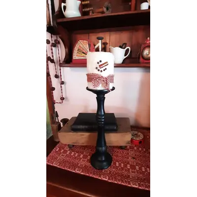 Black candle stick with snowman candle